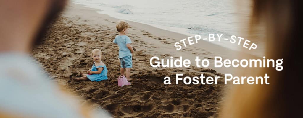 Two children play on the beach watched over by their foster parents.