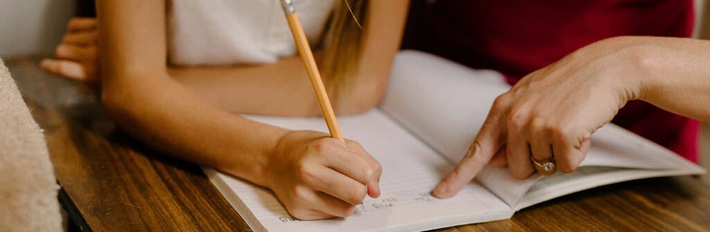 A volunteer tutors a child in foster care.