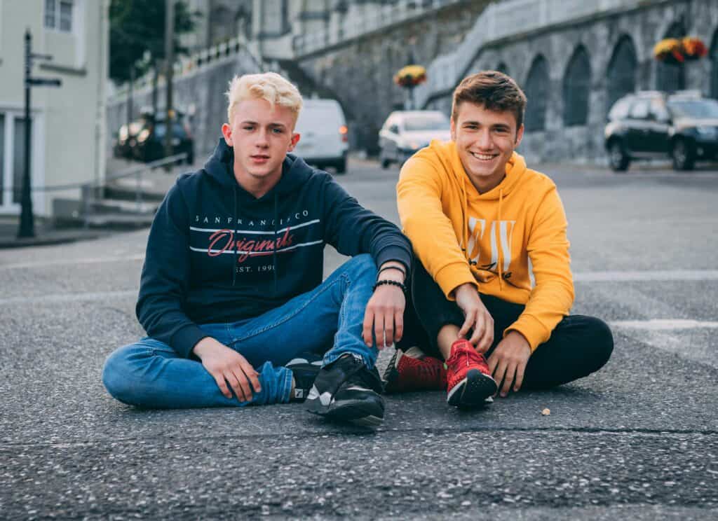 Teens like this young man, sitting next to another teen boy he is not related to, will have an easier time understanding foster care and adoption due to his age.