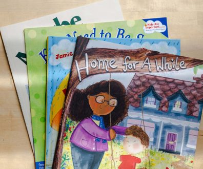 Four of the best books for children in foster care stacked on top of each other.