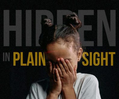 A girl covers her eyes with her hands to convey the hidden foster care crisis.