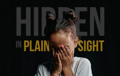 A girl covers her eyes with her hands to convey the hidden foster care crisis.